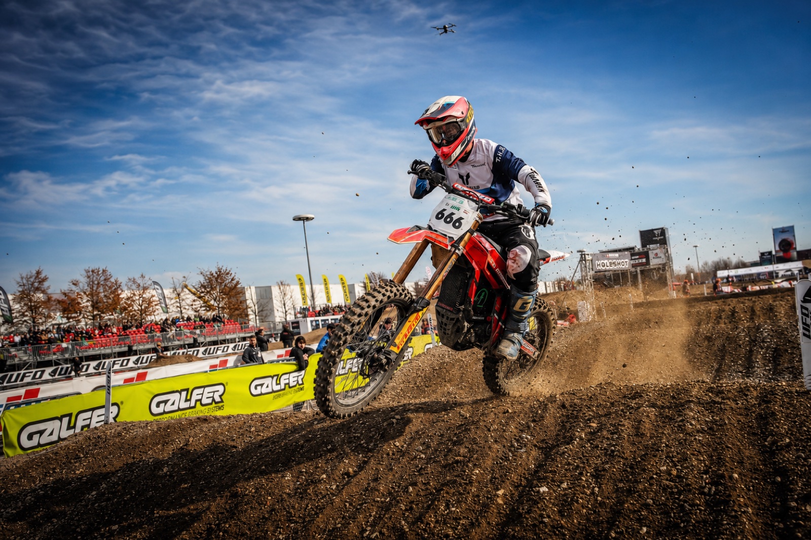 Pilota in salto su pista cross, moto Honda numero 666 in azione