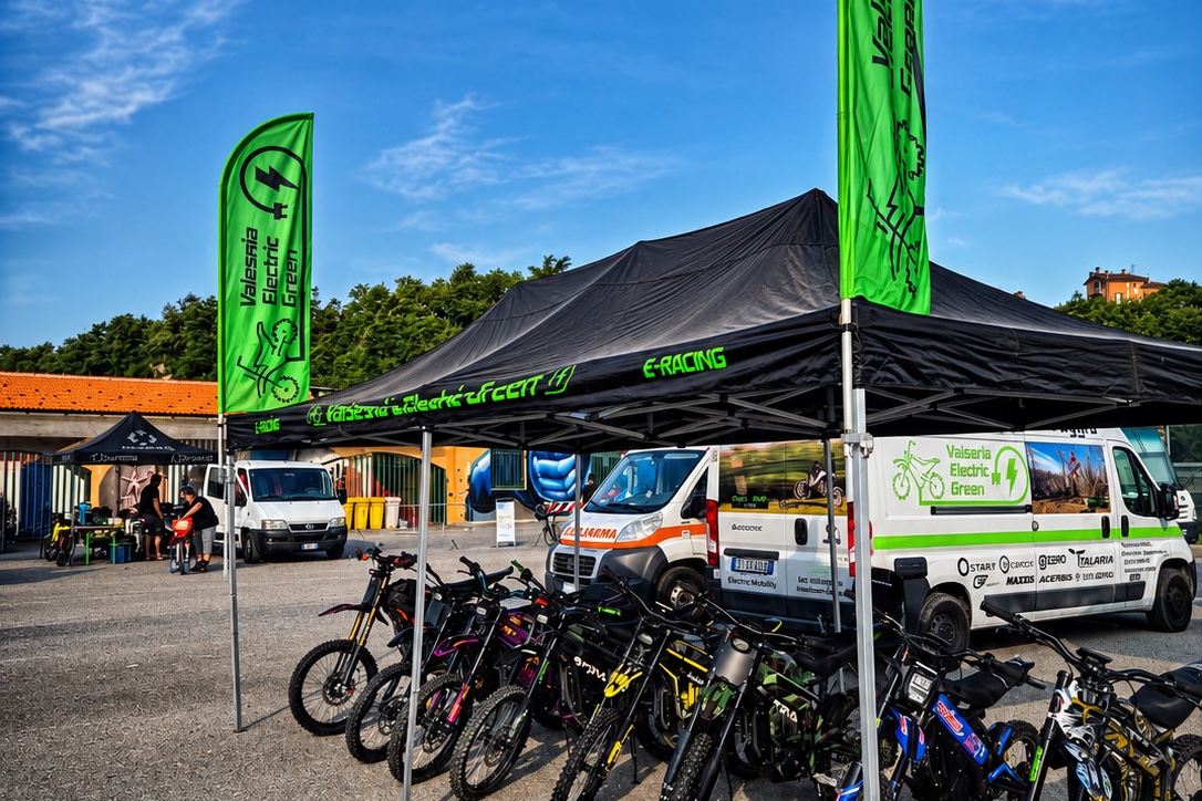 Stand Valsesia Electric Green con bandiere verdi e flotta di moto elettriche